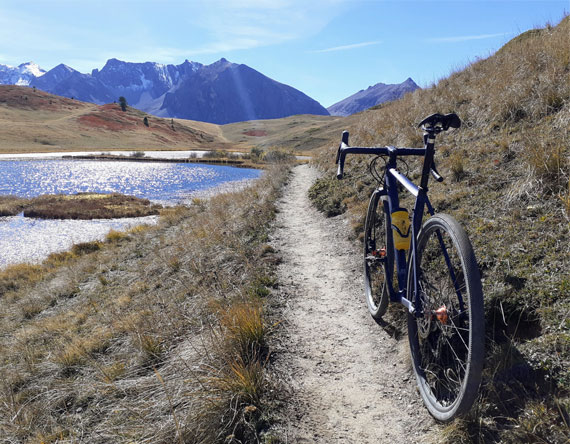 vélo gravel sur piste à coté d'un lac de montagne